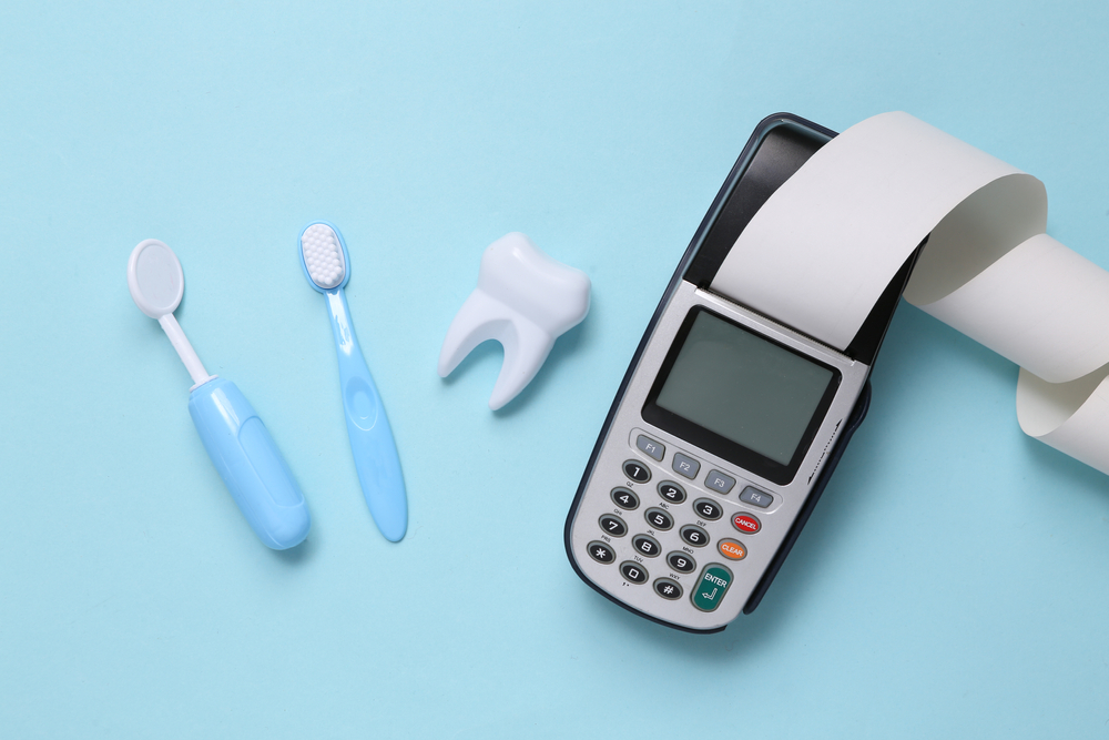 Toy dentist tools, payment terminal on a blue background.