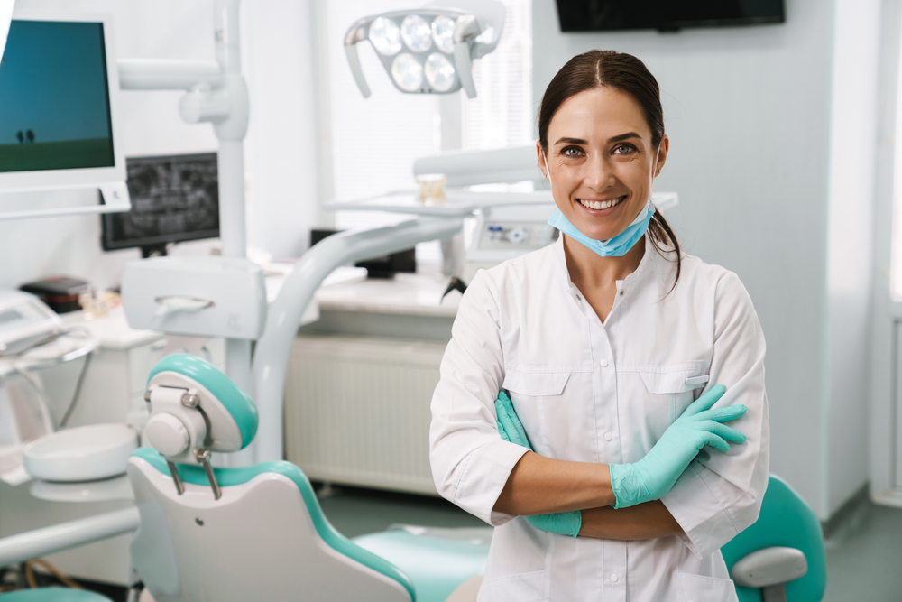 Woman Dentist Smiling in front of her exam room.