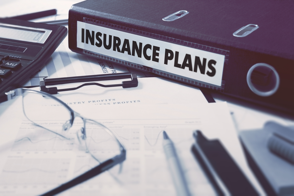 Insurance Plans - Ring Binder on Office Desktop with Office Supplies.